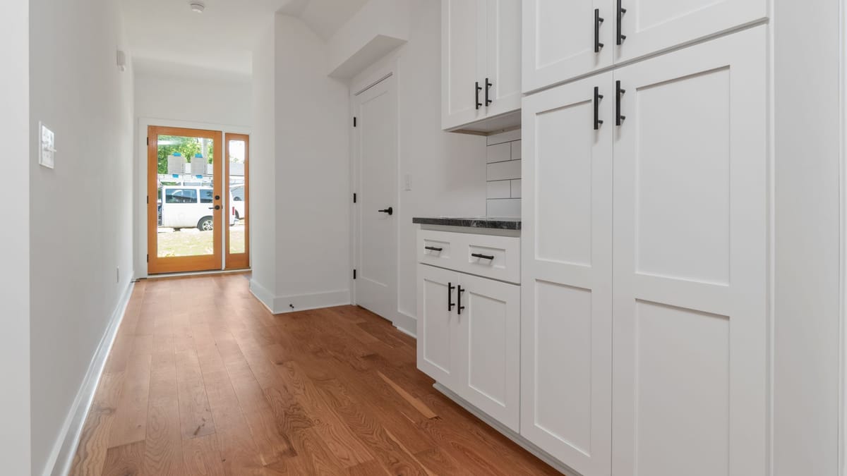 White Shaker cabinet doors with black pulls, showing the frame-and-panel construction